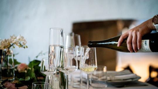 Personne servant du vin dans verre à vin dans un restaurant